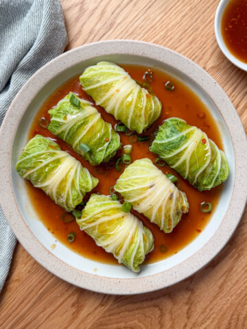 Chinese stuffed napa cabbage rolls with pork and shiitake mushroom filling in a savory sauce